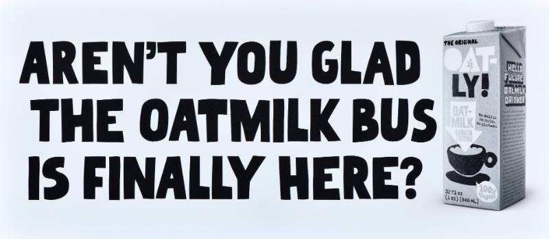 A poster with black text on a white background next to a carton of oatmilk
