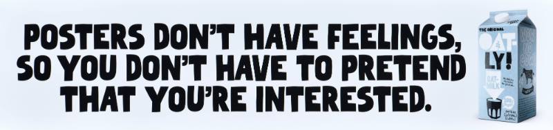 A poster with black text on a white background next to a carton of oatmilk