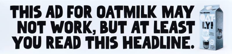 A poster with black text on a white background next to a carton of oatmilk