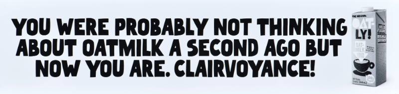 A poster with black text on a white background next to a carton of oatmilk