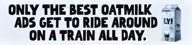 A poster with black text on a white background next to a carton of oatmilk