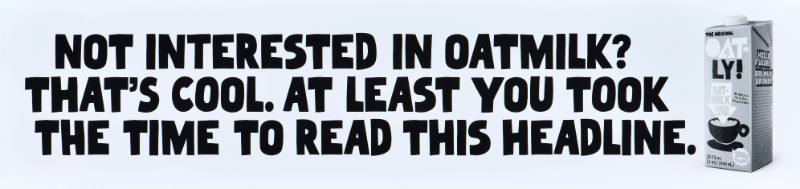 A poster with black text on a white background next to a carton of oatmilk