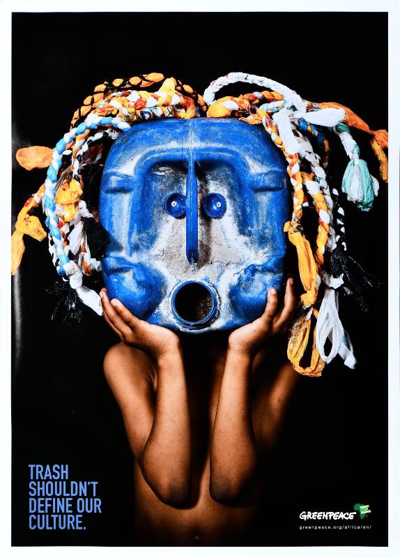 A poster of a Black figure holding a mask made out of trash