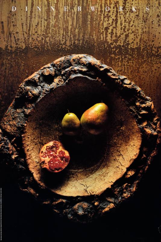 A poster of pears and a pomegranante inside a tree stump