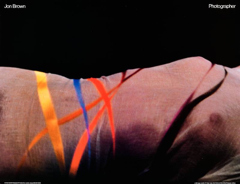 A poster of a nude woman's torso wrapped in colorful ribbons
