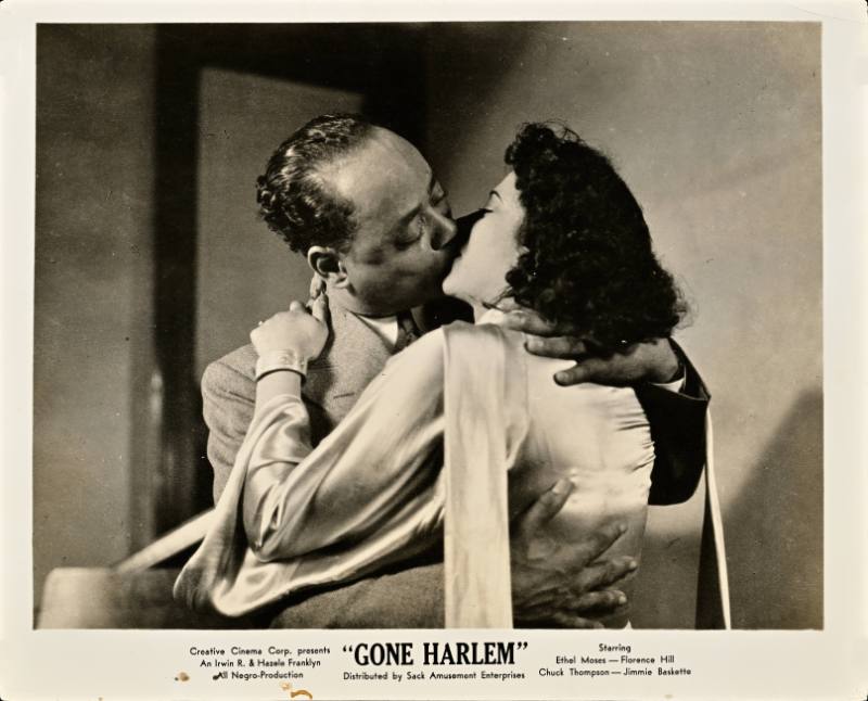 A printed card with a black and white photograph of a Black man and woman kissing