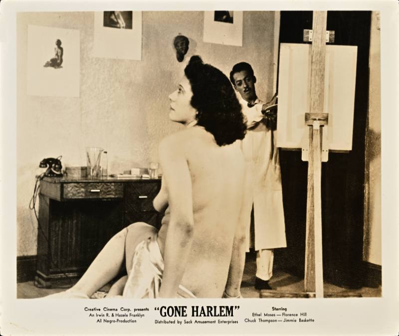 A printed card with a black and white photograph of a Black man painting a nude Black woman