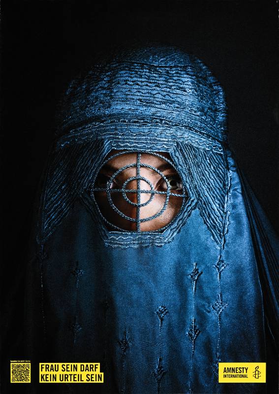 A poster of a woman in a blue hijab with a target embroidered over her face