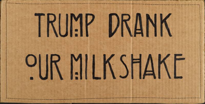 A poster with black stylized text on a cardboard background