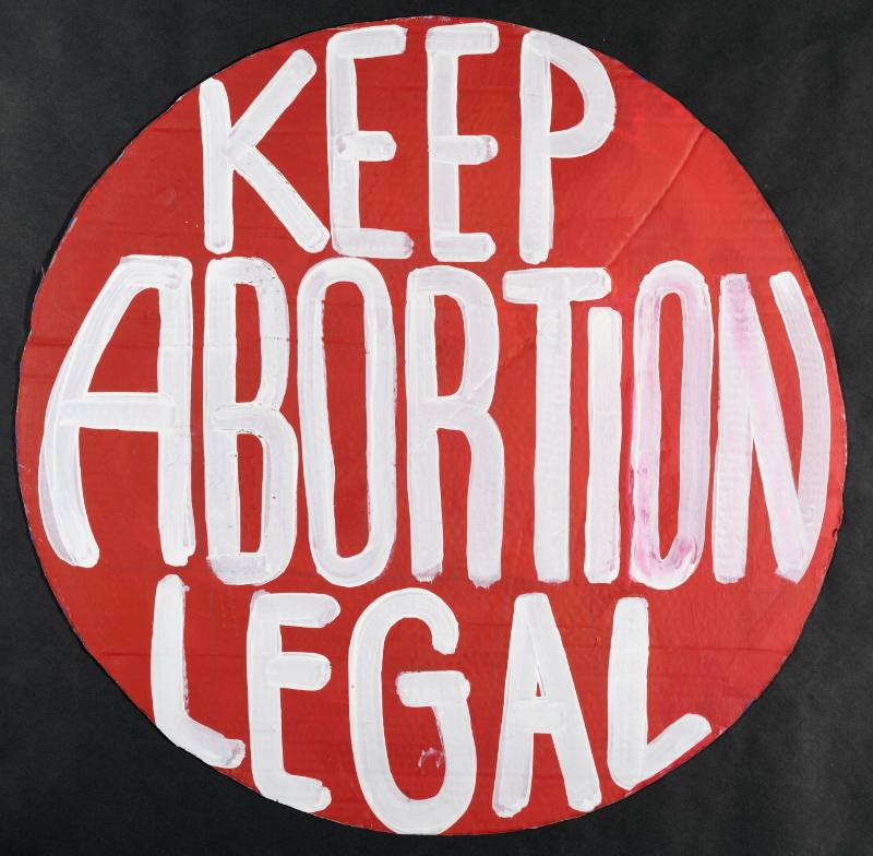 A poster with a red circle with white text on a black background